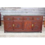 A Chinese hardwood sideboard, fitted four drawers over two pairs of cupboard doors with applied