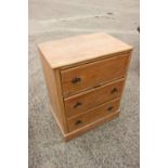 A stripped pine chest of three drawers, on block base, 27" wide x 17 3/4" deep x 34" high