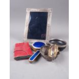An Egyptian silver photograph frame, a silver mounted wooden dish, a white metal two-handled bowl, a