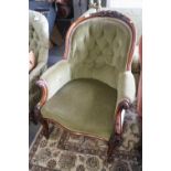 A Victorian carved walnut showframe tub armchair, button upholstered in a green velour, on