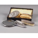 A pair of silver backed brushes, in box, another silver backed brush, a similar hand mirror and
