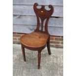 A 19th century mahogany scroll back hall chair with panel seat and turned supports