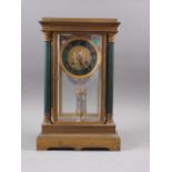 A 19th century gilt four-glass mantel clock, supported by four columns with green enamel and gilt