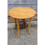 An Ercol elm Windsor circular two-tier occasional table, on splay supports, 23 1/2" dia x 24 1/2"