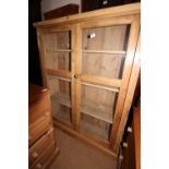 A 19th century waxed pine side cabinet enclosed two glazed doors, 41 1/2" wide x 12" deep x 50 1/