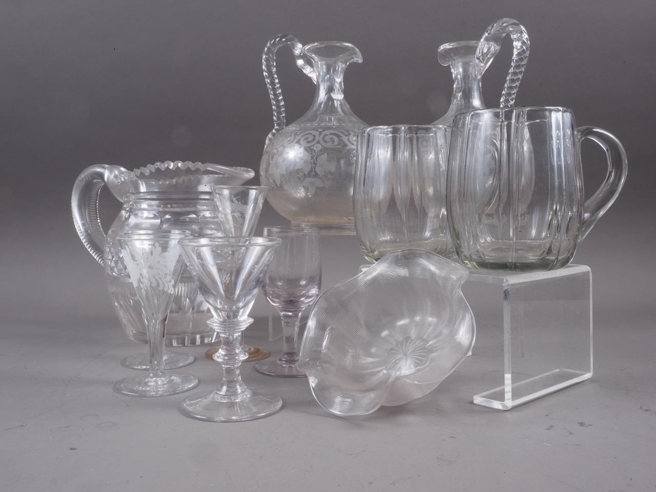 A pair of clear glass etched jugs with twisted handles, 7 1/4" high, a pair of glass mugs and