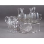 A pair of clear glass etched jugs with twisted handles, 7 1/4" high, a pair of glass mugs and