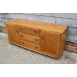 An Ercol elm 455 Windsor sideboard, fitted three central drawers and flanking cupboards, on shepherd