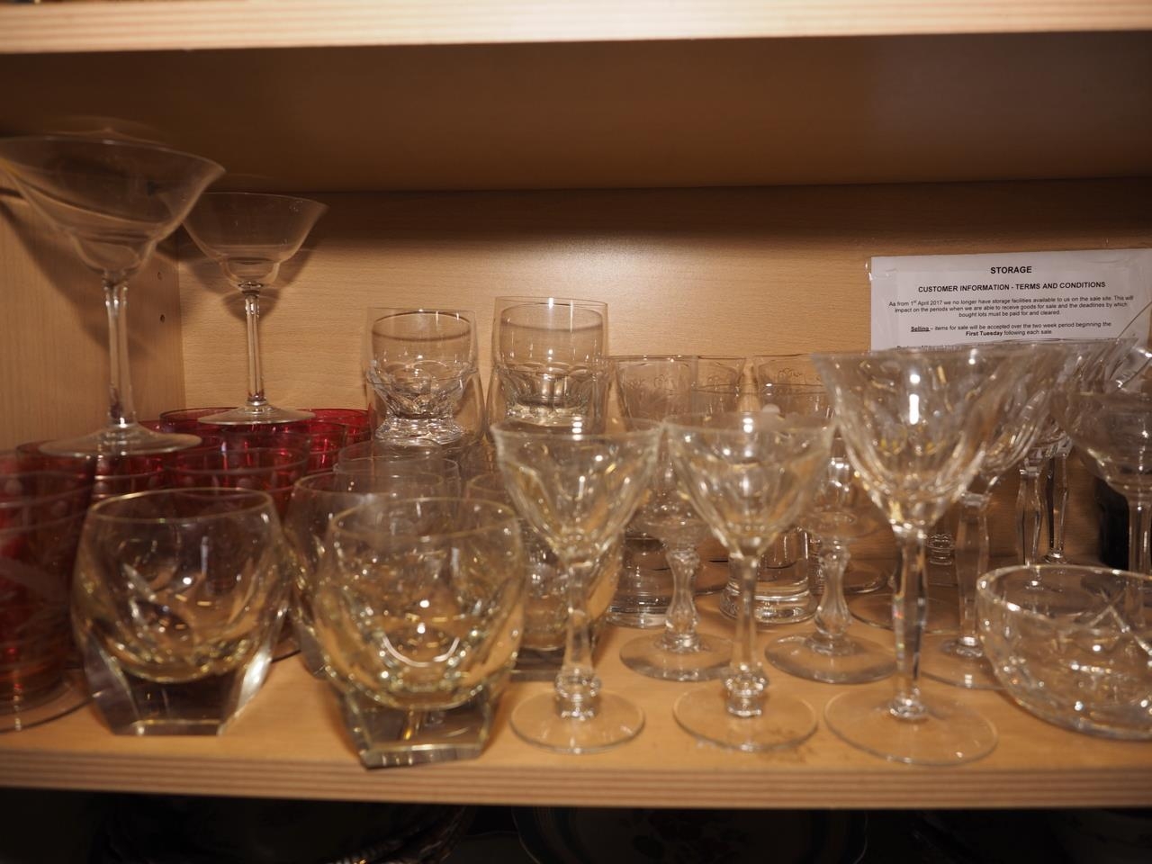 A quantity of mostly clear glass drinking glasses, including various pedestal glasses and seven