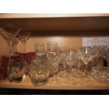 A quantity of mostly clear glass drinking glasses, including various pedestal glasses and seven