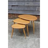 A nest of three Ercol elm 354 "pebble" tables, largest 25" wide x 17" deep x 16" high