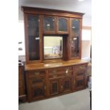 An Edwardian carved walnut sideboard/dresser, the upper section fitted four glazed doors and central