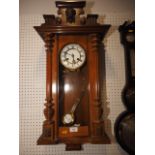 A late 19th century walnut cased Vienna type wall clock with white enamel dial and eight-day