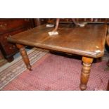 A walnut extending dining table with one extra leaf, on fluted supports, 70 1/2" x 40 1/2" when