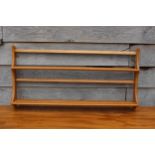 An Ercol elm open plate rack, 38" wide x 5" deep x 19" high