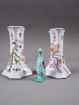 A pair of Meissen candlesticks, decorated with mythical beast and flowers in a landscape, 4" high,