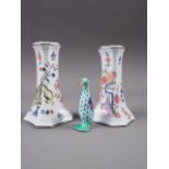 A pair of Meissen candlesticks, decorated with mythical beast and flowers in a landscape, 4" high,