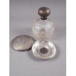 A clear and etched glass silver topped scent bottle, a silver dish inset with a Victorian coin,