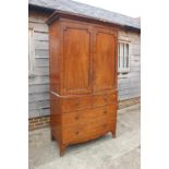 An early 19th century mahogany linen press, the upper section enclosed two doors over two faux