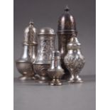 A silver sugar castor with embossed floral decoration, 5" high, two other castors, two pepper pots