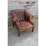 A "Chesterfield" armchair, upholstered in a brown leather, on square taper stretchered supports