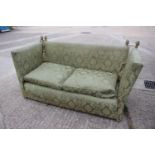 An early 20th century Knole settee with two down loose seat cushions, upholstered in a green