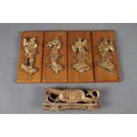 Four Chinese gilt and red lacquer figural plaques, on hardwood panels, and a similar finial