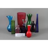 An assortment of decorative coloured glass vases, pedestal drinking glasses and other items