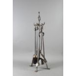 A burnished steel companion stand and fire implements and another matching set.