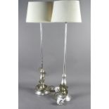 A pair of silvered table lamps, on circular bases, with oval shades, 33" high