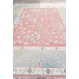 A flat weave carpet of geometric design, in faded shades of blue, pink, green and neutral, 169" x