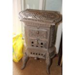 A grey painted cast iron stove with pierced decoration, on cabriole supports, 19" wide x 13" deep