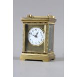 A brass cased carriage clock, white enamel dial inscribed "Harrods Ltd London SW", 6" high with