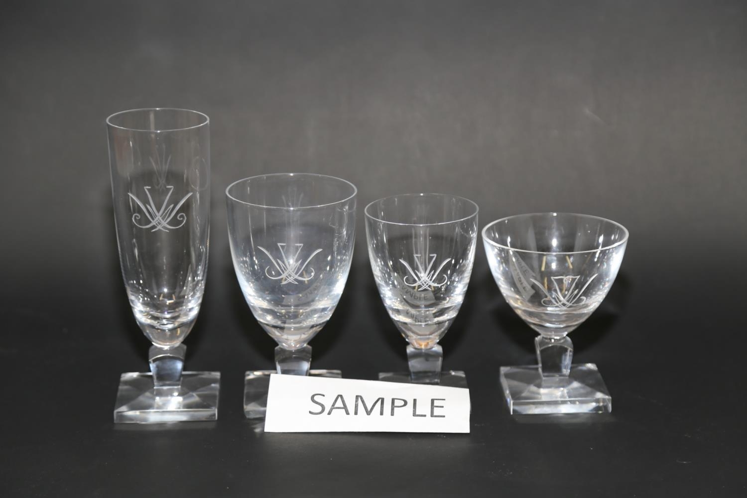 A quantity of clear table glass with engraved decoration, on square bases