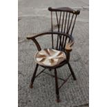 A polished as walnut spindle back elbow chair with circular panel seat, on turned and stretchered