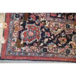 A Persian style carpet of traditional design with central medallion on a red ground in shades of