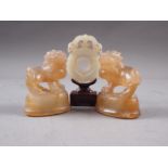 A Chinese green jade roundel, on stand, 2 3/4" high overall, and a pair of similar carved jade