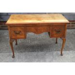 A figured walnut dressing table, fitted three drawers, on cabriole supports, 41" wide x 20" deep x