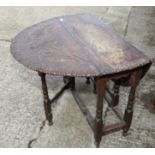 An 18th century oak oval gateleg table with later carved decoration, on turned supports, 36" wide