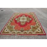 A rug of traditional Continental design on a red ground, 114" x 80" approx, and a smaller similar