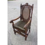 A Restoration design carved walnut carver chair with oval cane back and seat, on barley twist