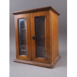 A smoker's oak compendium enclosed two glazed doors and two drawers (locked)