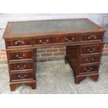 A well reproduced mahogany double pedestal desk with green tooled leather top, fitted nine