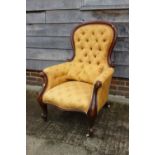 A Victorian mahogany showframe button back armchair, upholstered in a gold floral fabric, and a