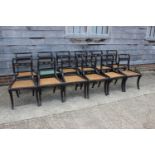A set of twelve Regency ebonised and brass rope mounted rope twist bar back dining chairs with