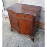 A mahogany serpentine front cupboard, fitted one drawer over two doors, on splay bracket supports,