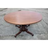 A William IV mahogany oval table, on turned and carved column and quadruple scroll splay support,