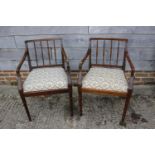 A pair of spindle back elbow chairs with drop-in seats, on square taper supports