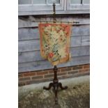 A 19th century brass and mahogany adjustable pole screen with needlepoint panel, on tripod splay