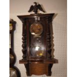 An American walnut cased wall clock with eagle surmount and brass faced eight-day movement, on later